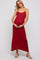 woman wearing a red knitted maternity maxi dress and holding her baby bump