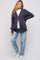 woman wearing a navy blue ribbed maternity cardigan with buttons, paired with a white t-shirt and light blue jeans