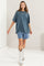 woman wearing a faded blue oversized t-shirt with shorts and shiny silver cowboy boots