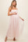 woman wearing a light pink maternity maxi dress with sheer overlay and adjustable straps, showing her baby bump