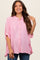 woman wearing a pink and white striped maternity top with buttons and loose sleeves, smiling at the camera