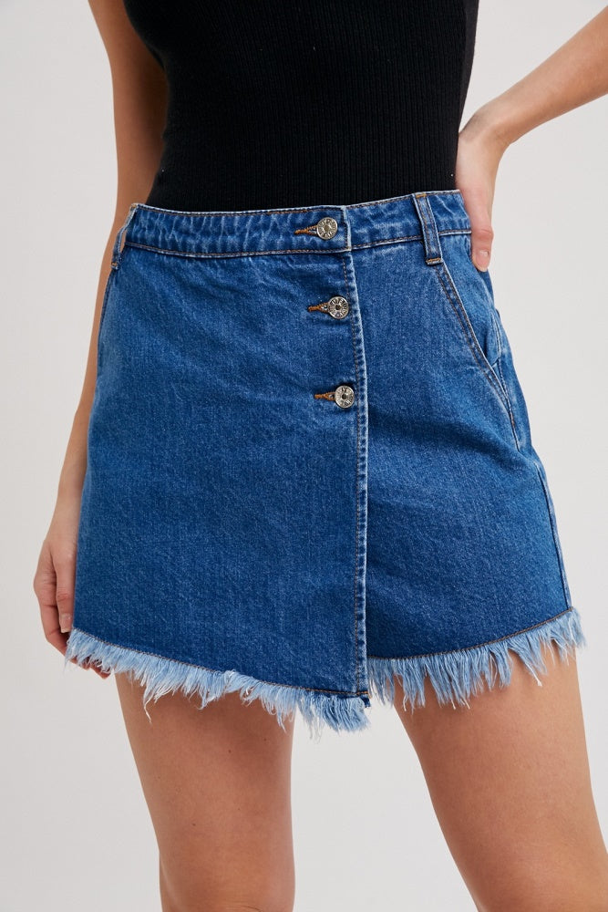 woman wearing a blue denim mini skirt with frayed hem and button detailing