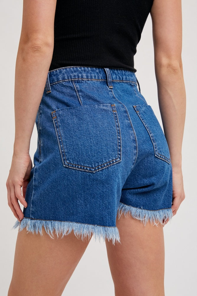 woman wearing high-waisted blue denim shorts with frayed hem and back pockets