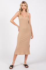 woman wearing a beige ribbed midi dress with side slits and black slide sandals