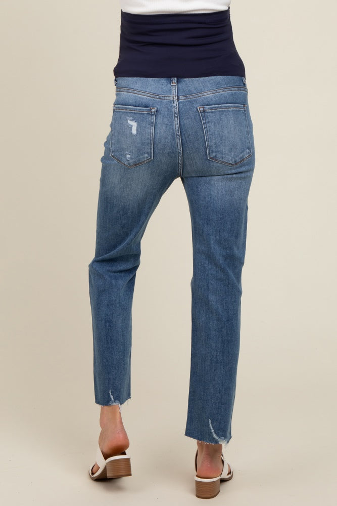 woman wearing light blue distressed maternity jeans with a straight leg and a frayed hem, seen from the back