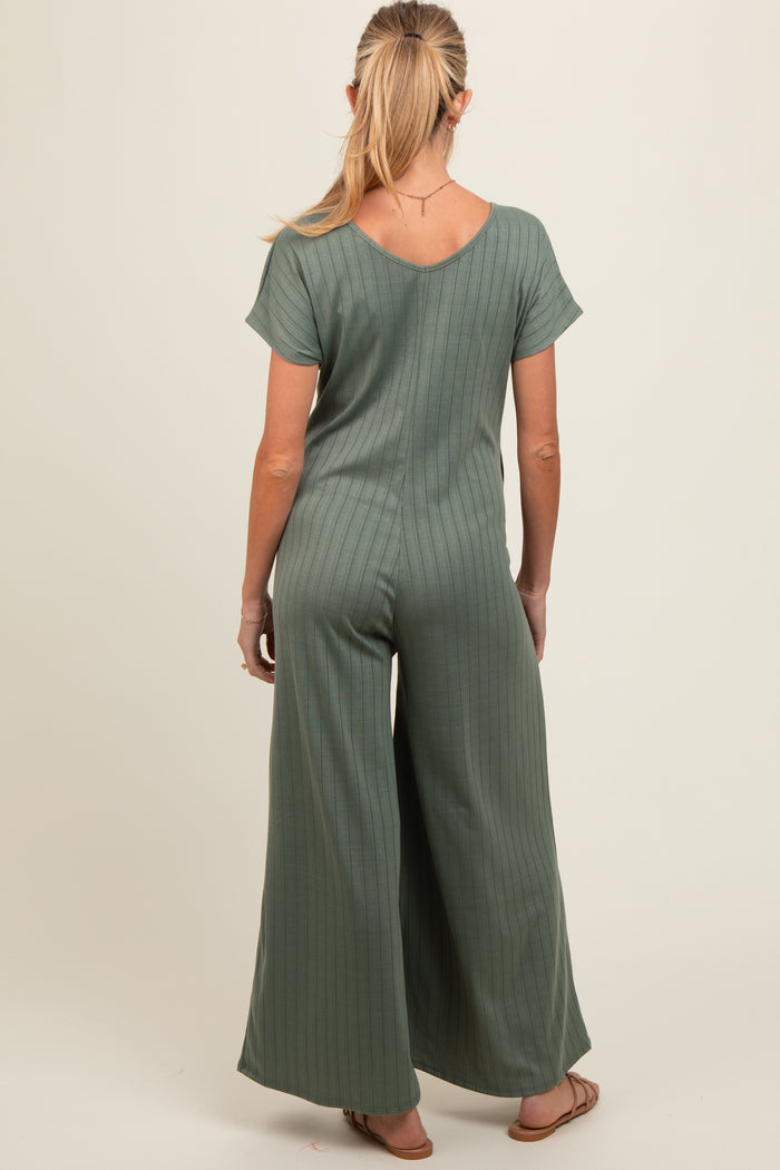 woman wearing a muted green maternity jumpsuit with short sleeves and wide leg, seen from the back