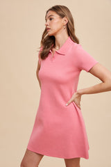 woman wearing a pink short sleeve polo dress with a relaxed fit and collar