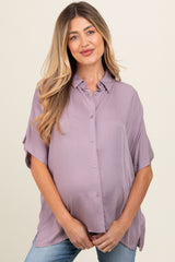 woman wearing a lavender maternity button-up shirt and showing her baby bump