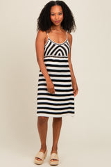woman wearing a black and white striped spaghetti strap dress with a fitted waist and relaxed skirt