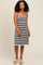 woman wearing a black and white striped spaghetti strap dress with a fitted waist and relaxed skirt
