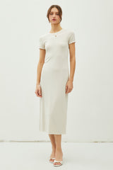 woman wearing a cream short sleeve midi dress with a fitted silhouette and a round neckline