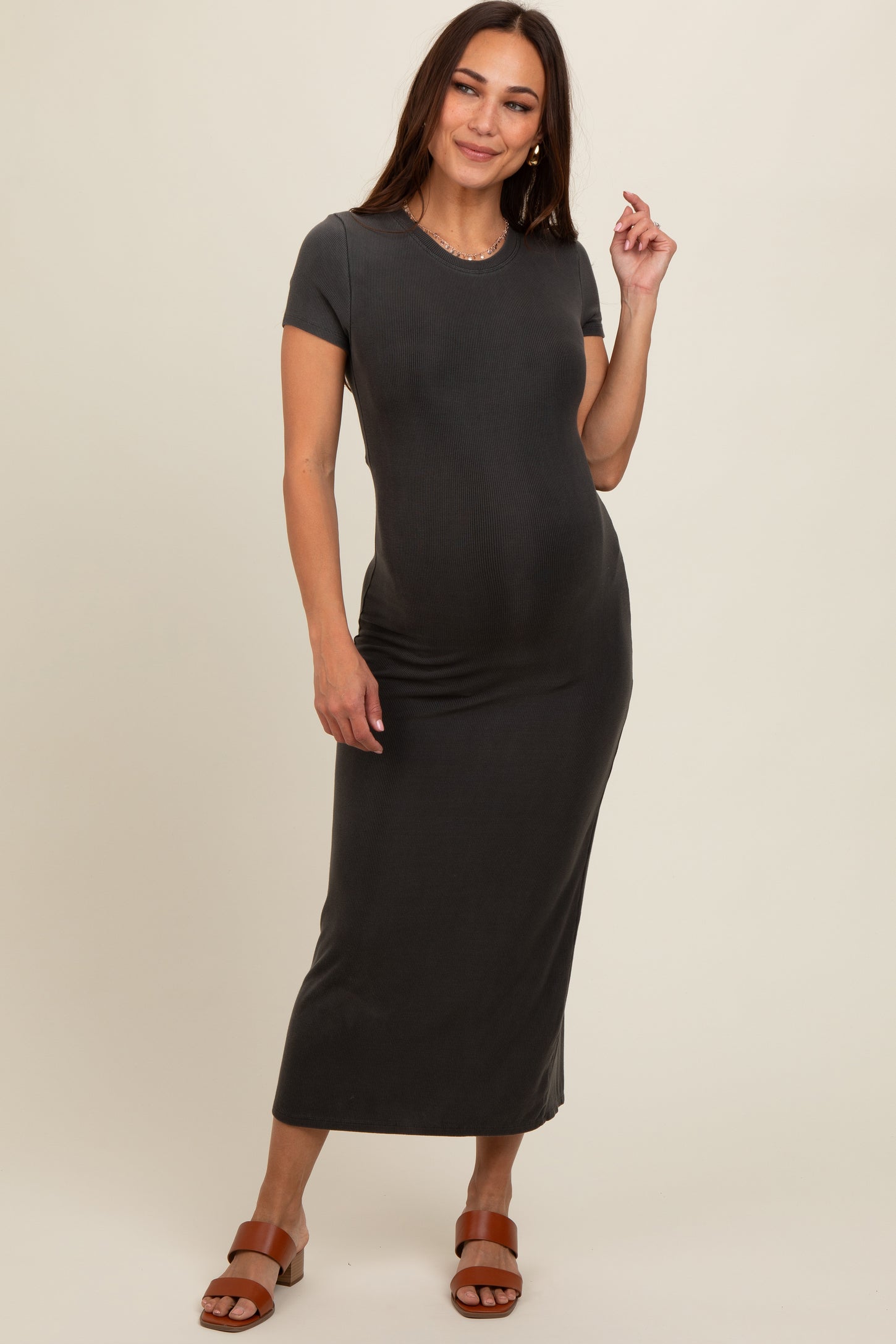woman wearing a dark gray short sleeve maternity dress that fits over her baby bump