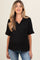 woman wearing a black short sleeve polo maternity top and blue jeans, baby bump is visible