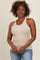 woman wearing a beige ribbed tank top with a scoop neckline and jeans