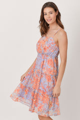 woman wearing a lavender floral tiered sundress with orange and purple flowers and thin spaghetti straps
