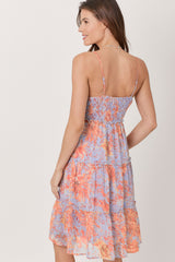 woman wearing a floral smocked sundress with adjustable straps and a tiered skirt, viewed from the back