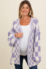 woman wearing a purple and white checkered maternity cardigan over a white top, showing a baby bump