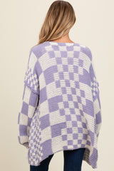 woman wearing a lavender and white checkered maternity sweater with oversized fit and open back detail.