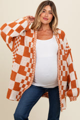 woman wearing an orange and white checked maternity cardigan over a white top, showing her baby bump and paired with jeans