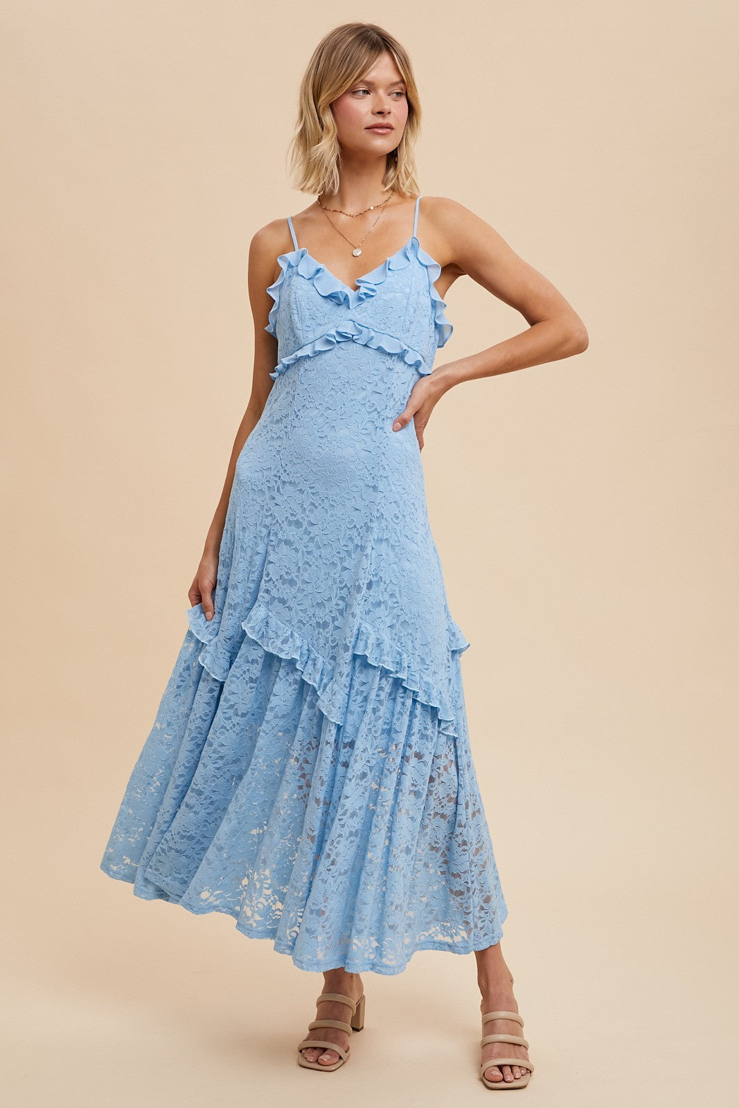 woman wearing a light blue lace maxi dress with ruffle details and spaghetti straps