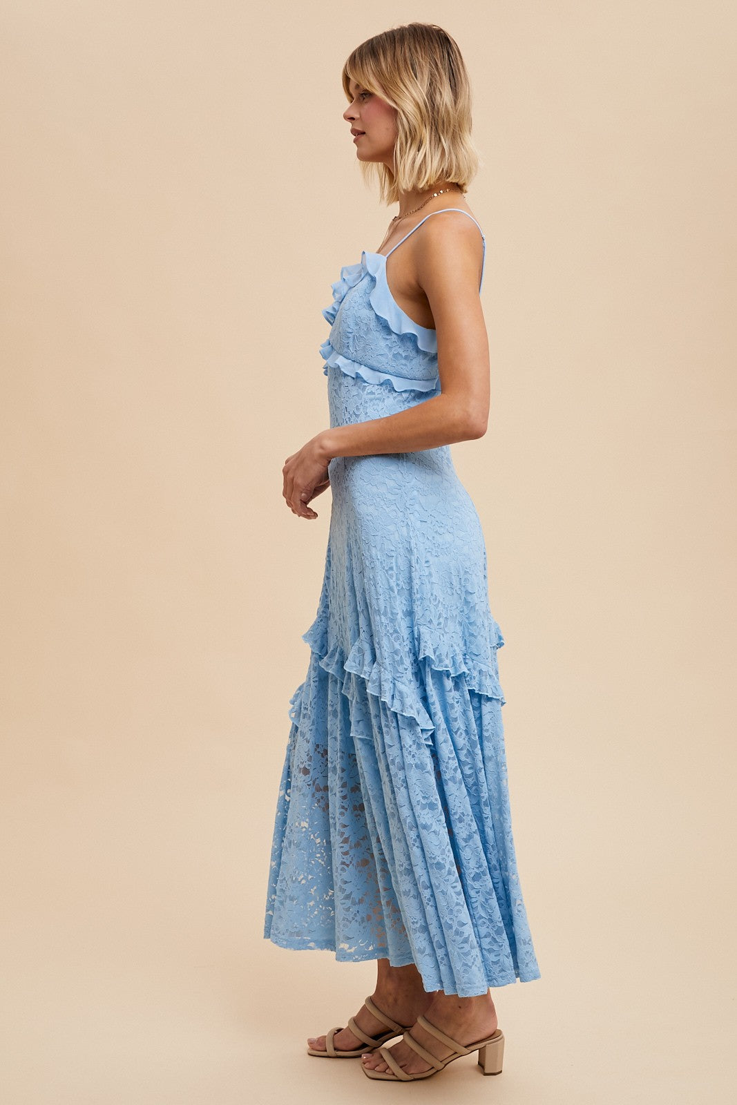 woman wearing a light blue lace maxi dress with ruffles and a fitted bodice