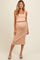 woman wearing a nude ribbed maternity crop top and matching midi skirt with a fitted silhouette