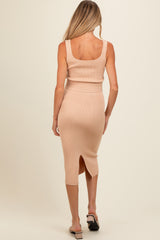 woman wearing a beige ribbed maternity tank top and matching midi skirt, with a side slit, viewed from the back