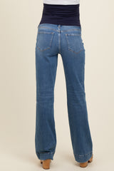 woman wearing light blue maternity jeans viewed from the back, showing a flared leg design and stretchy waistband