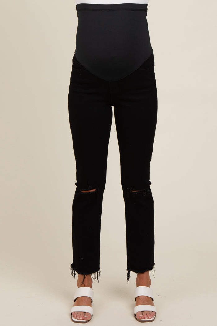 woman wearing black maternity jeans with a belly support band and distressed hem
