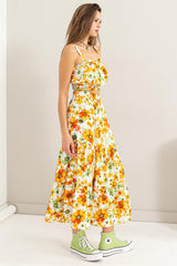 woman wearing a yellow floral two-piece crop top and maxi skirt with green high-top sneakers