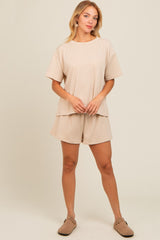 woman wearing a beige striped loungewear set with a loose top and matching shorts