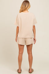 woman wearing a beige ribbed short sleeve top and matching shorts, viewed from the back