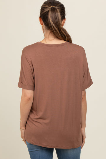 woman wearing a brown maternity top with rolled sleeves and a relaxed fit, viewed from the back