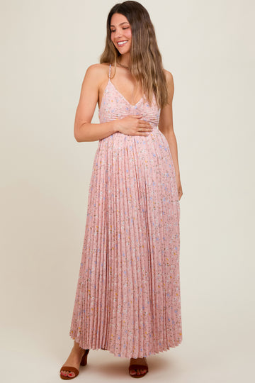 woman wearing a light pink floral maternity maxi dress with pleated detailing and a v-neckline