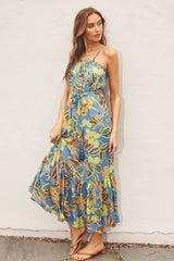 woman wearing a blue floral maxi dress with spaghetti straps and a tiered skirt