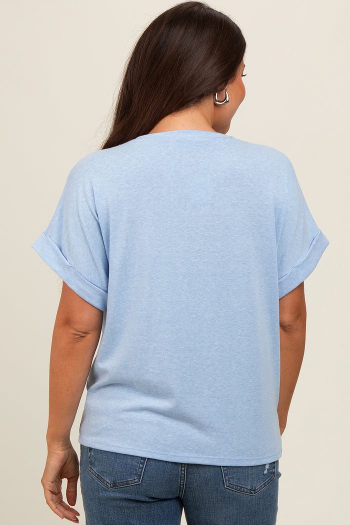 woman wearing a light blue maternity top with rolled sleeves, viewed from the back