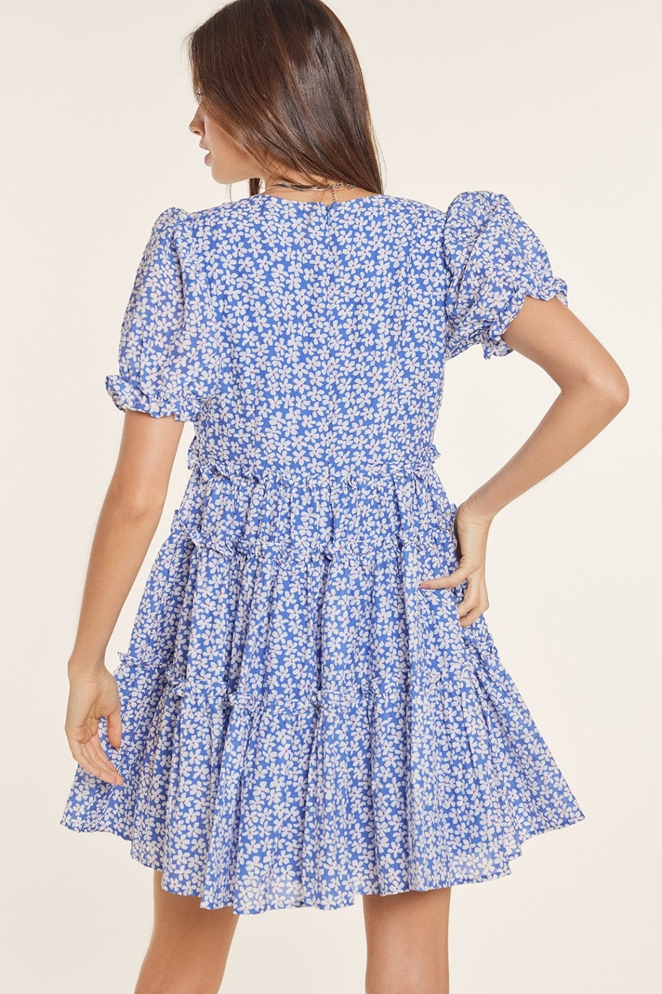 woman wearing a blue floral puff sleeve dress with a tiered skirt
