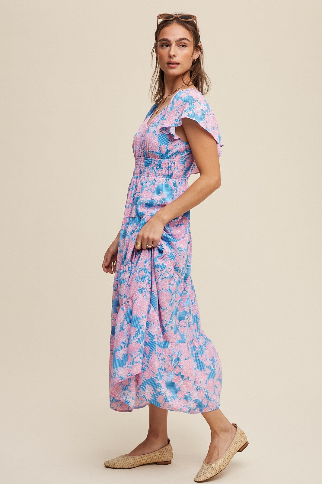 woman wearing a pink and blue floral maxi dress with short flutter sleeves and a smocked bodice