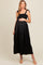 woman wearing a black maternity maxi dress with smocked bodice and ruffled bottom, holding her baby bump