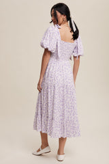 woman wearing a lavender floral maxi dress with puff sleeves and a shirred back, showing a tiered skirt