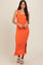 woman wearing a bright orange ribbed maxi dress with side slits and scoop neckline