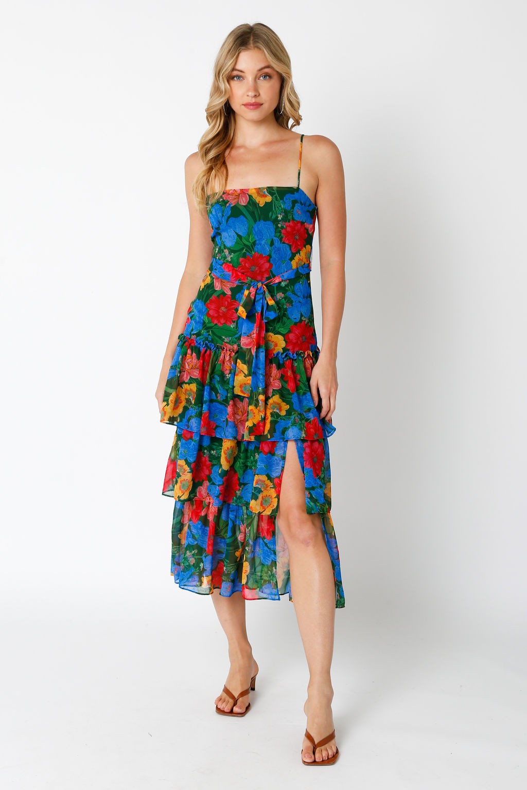 woman wearing a floral print tiered sundress with a high slit and adjustable straps