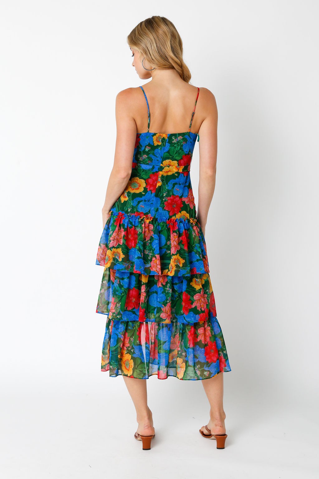 woman wearing a colorful floral tiered maxi dress with a spaghetti strap back detail