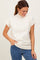 woman wearing a cream short sleeve mock neck sweater and blue jeans, smiling while looking down