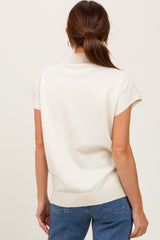 woman wearing a cream short sleeve knit top with a high neckline and relaxed fit, viewed from the back