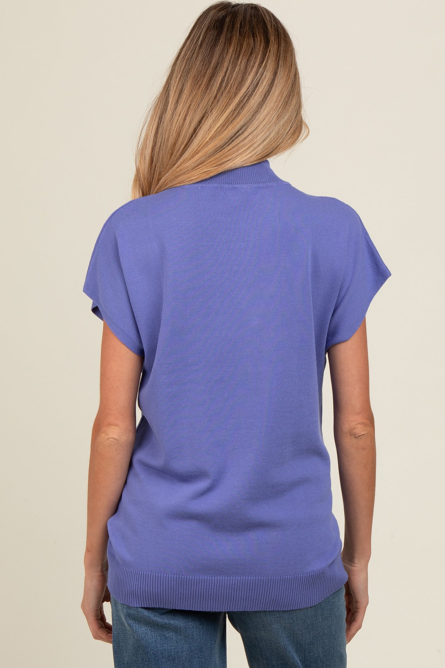 woman wearing a purple short sleeve maternity top, showing the back view with a relaxed fit