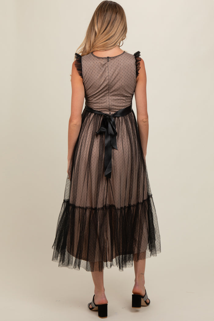 maternity wear in a brown polka dot dress with black tulle overlay and ruffled sleeves, model shown from the back