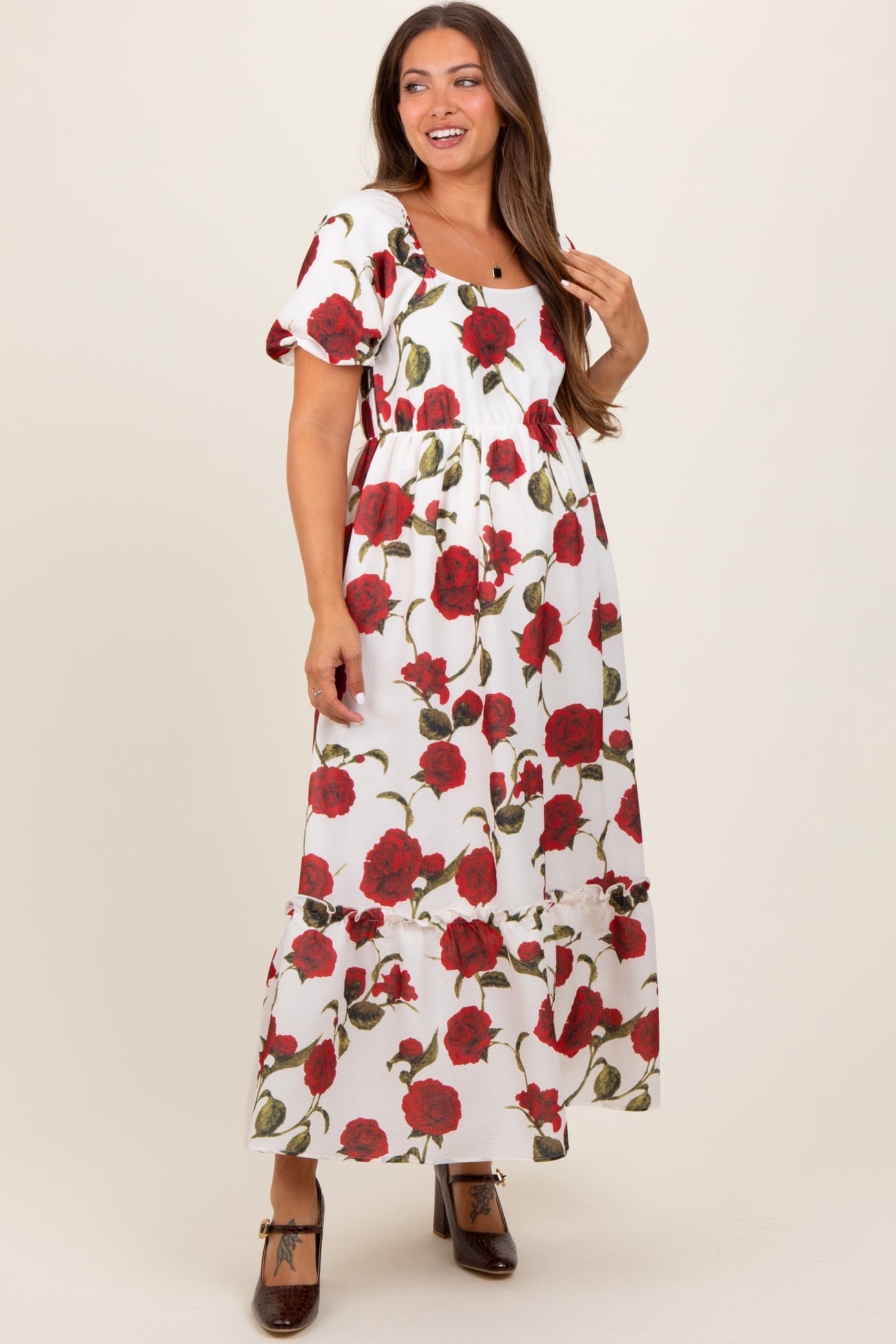 woman wearing a floral maternity maxi dress with puff sleeves and a square neckline, showing a baby bump
