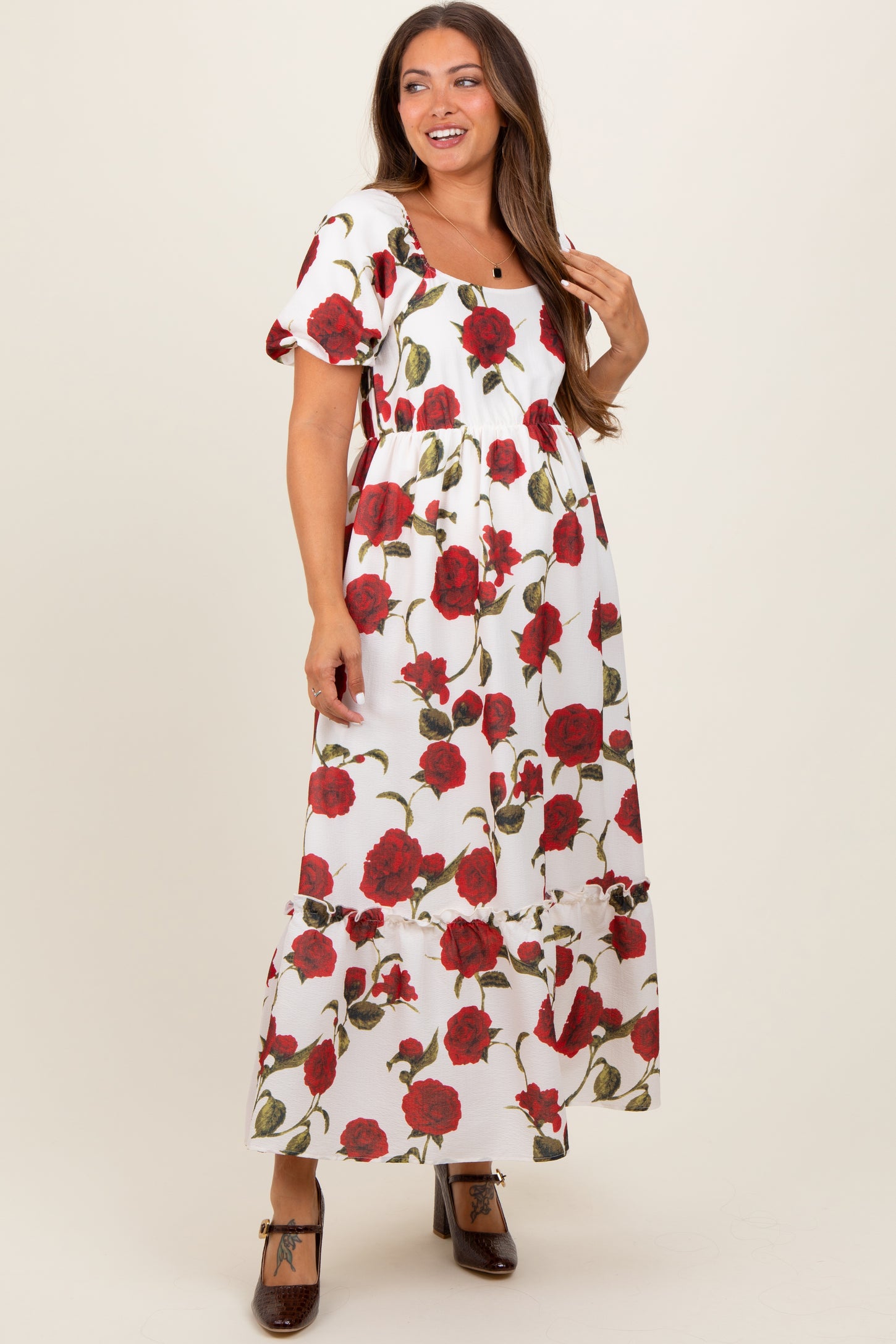 woman wearing a floral maternity maxi dress with puff sleeves and a square neckline, showing a baby bump