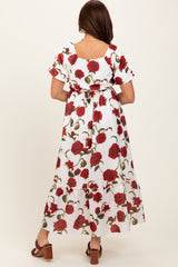 woman wearing a white floral maxi dress with red roses and ruffled sleeves, showing the back view